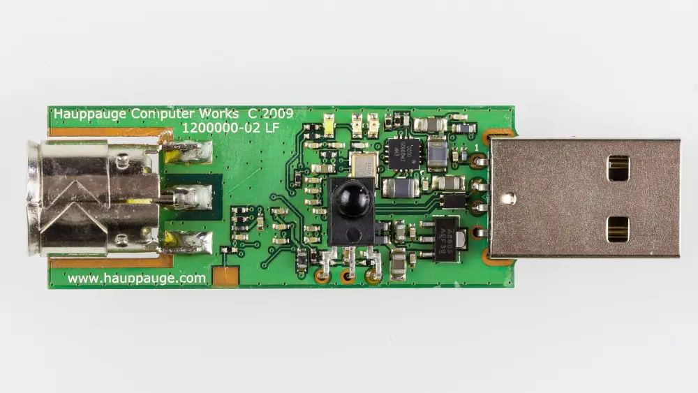 A Hauppauge WinTV USB tuner stick with its case removed, showing the aerial socket at one end and the USB plug at the other