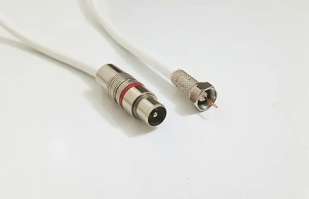 Two aerial leads side by side: a PAL plug with a plain metal barrel on the left, and a smaller threaded F plug with a bare centre wire on the right